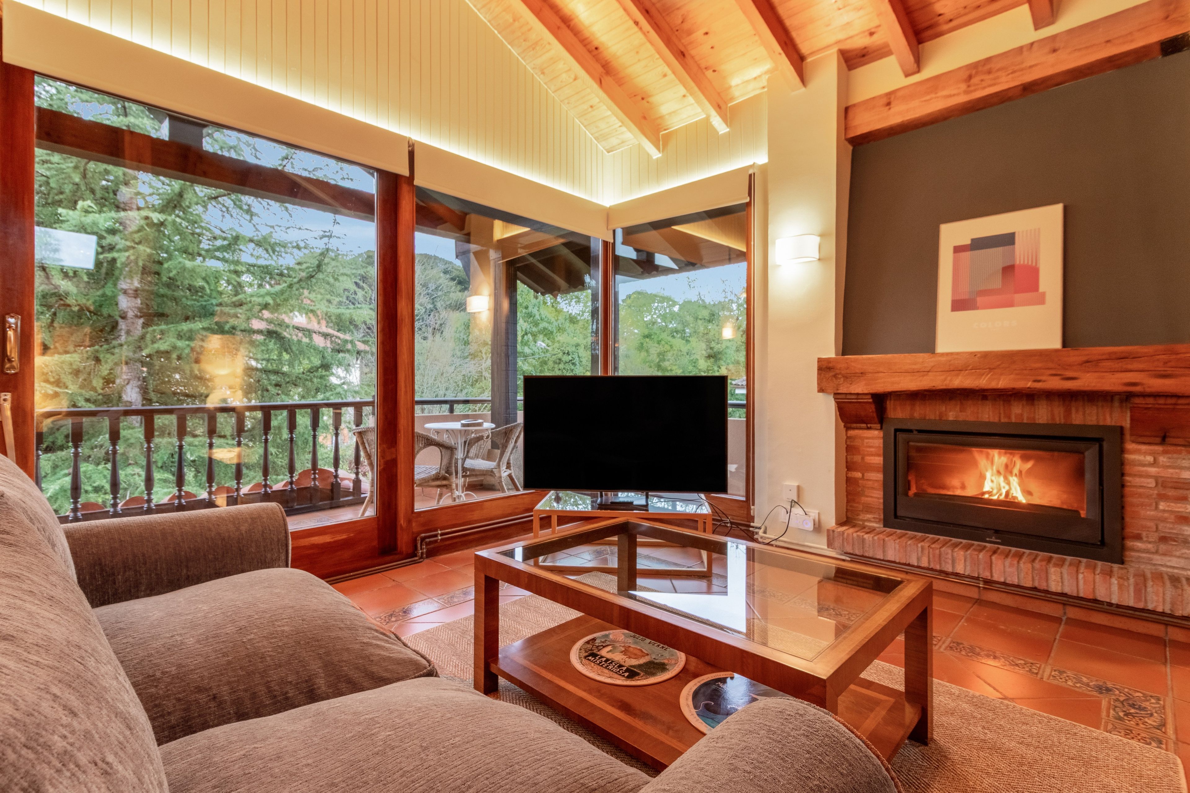 Una sala de estar moderna con chimenea, televisor de pantalla plana y asientos cómodos.