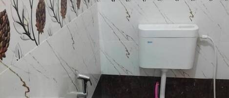 A bathroom with a white sink, a toilet, and a wall with a floral pattern.
