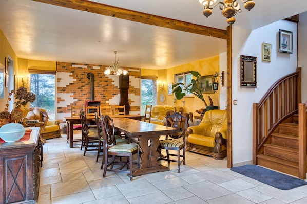 A dining area with a brick wall, wooden table, and chairs.