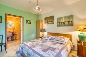 A bedroom with a bed, a wooden wardrobe, a desk with a chair, and a door leading to another room. - Bed and Breakfast 'Chambre La Plage' with Shared Garden and Wi-Fi (Saint-Léonard)