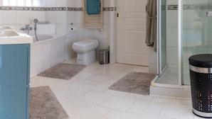 A bathroom with a bathtub, toilet, and shower area. - Apartment 10 pers Terrace &Palais des Festivals (Cannes)