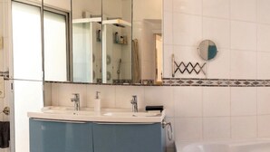A bathroom with a double sink vanity, a bathtub, and a mirror. - Apartment 10 pers Terrace &Palais des Festivals (Cannes)