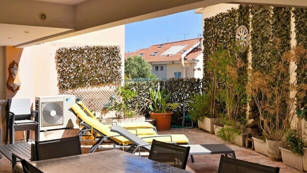 An outdoor patio with a table and chairs, a sun lounger, and potted plants. - Apartment 10 pers Terrace &Palais des Festivals (Cannes)