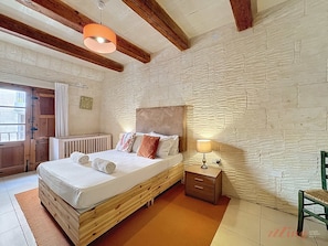 Une chambre à coucher avec un lit en bois, une table de chevet, une lampe et une chaise.