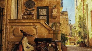 A narrow cobblestone street with a vintage motorcycle parked against a stone building. - Mia - Your Gozo Haven with Pool (Ix-Xagħra)