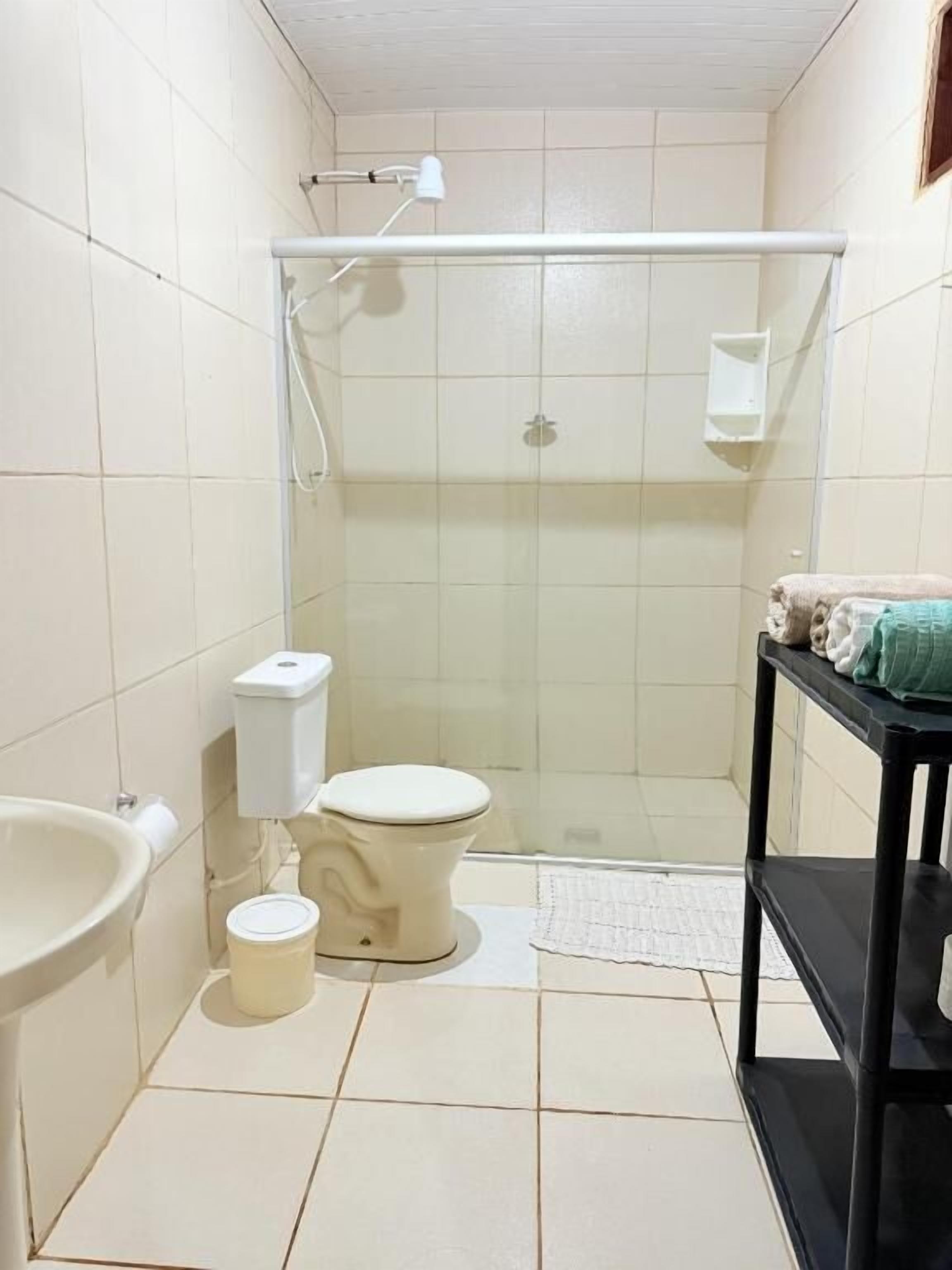 A small bathroom with a toilet, sink, and shower.