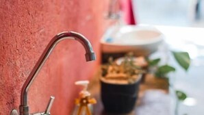 A bathroom with a pink sink and a faucet mounted on a red wall. - Pequizeiro Eco Pousada (Cavalcante)