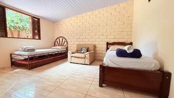 Ein Schlafzimmer mit Backsteinwand, einem Holzbett, einer Couch und einem kleinen Tisch.