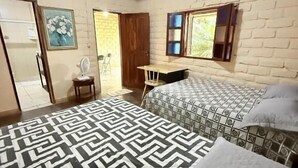 A bedroom with a bed, a desk, and a chair. There is a door leading to a balcony. - Pequizeiro Eco Pousada (Cavalcante)