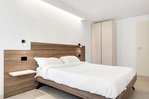 Una camera da letto moderna con una testiera in legno, un comodino e un armadio.