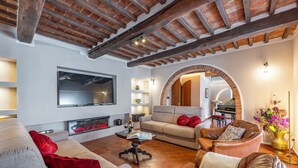 Un amplio salón con chimenea, sofás y un piano.
