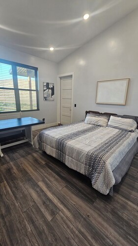Serene large bedroom with private entrance, bathroom, and thermostat.