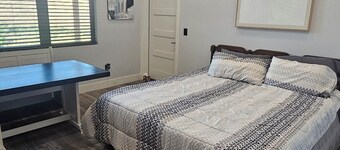 Serene large bedroom with private entrance, bathroom, and thermostat.