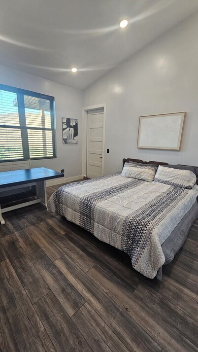 Serene large bedroom with private entrance, bathroom, and thermostat.