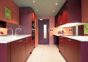 Eine moderne Küche mit Edelstahlgeräten, einem Spülbecken und einer Arbeitsplatte.