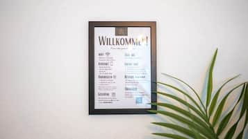 Letrero de bienvenida que muestra información de contacto, WiFi, servicio de taxis y reseñas.