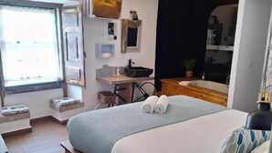 Quarto moderno com uma cama grande, uma escrivaninha e uma janela.