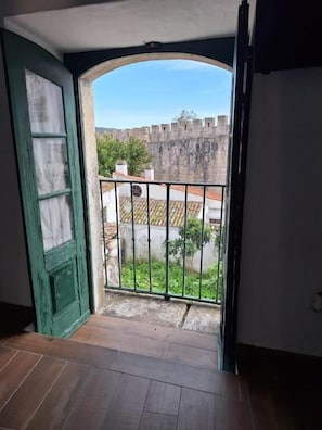 A room with a view of a courtyard and a stone wall. - Lovin Book Guesthouse (Óbidos)