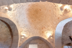 An arched stone ceiling with embedded lighting fixtures.
