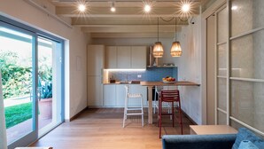 A modern kitchen with a central island, pendant lights, and a view of the outdoors. - Lavender Suite Bath Cavallone Directly on the beach, with TENT INCLUDED (Lido di Camaiore)