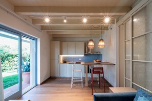 A modern kitchen with a central island, pendant lights, and a view of the outdoors. - Lavender Suite Bath Cavallone Directly on the beach, with TENT INCLUDED (Lido di Camaiore)
