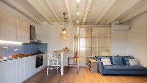 A modern kitchen with white cabinets, a blue backsplash, and a wooden dining table. - Lavender Suite Bath Cavallone Directly on the beach, with TENT INCLUDED (Lido di Camaiore)