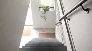 A staircase with a metal handrail, a hanging plant, and a window at the top. - Holiday Home "Gîte Les Aubennes" with Private Terrace, Garden & Wi-Fi (Fromelennes)