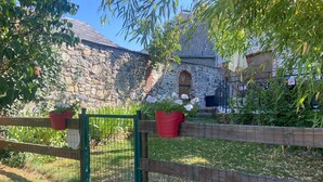 A stone building with a wooden fence, potted plants, and a gate. - Holiday Home "Gîte Les Aubennes" with Private Terrace, Garden & Wi-Fi (Fromelennes)