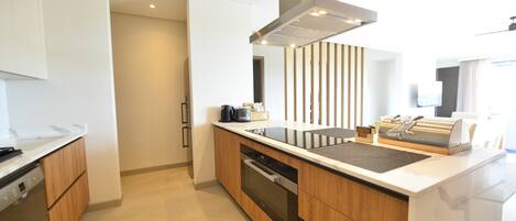 A modern kitchen with wooden cabinets, a black oven, and a stainless steel range hood.