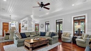 A spacious living room with a sectional sofa, a wooden coffee table, and a ceiling fan. - Award-Winning Resort Amenities | Fishers Alley 2 by Wild Dunes (Isle Of Palms)