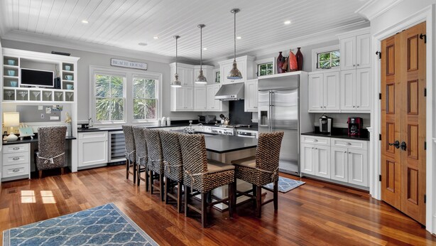 A modern kitchen with white cabinetry, a central island, and pendant lighting. - Award-Winning Resort Amenities | Fishers Alley 2 by Wild Dunes (Isle Of Palms)