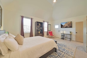 A bedroom with a large bed, a desk, a chair, and a door. - Luxury New Build in Western District OKC for a large family (Oklahoma City)