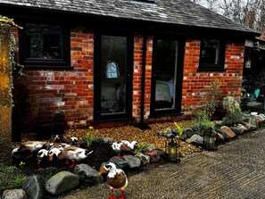 A brick house with three windows and a garden with ducks. - Pets- Garden- Bbq- Parking- Fireplace- Sleeps 6 (Llanrwst)
