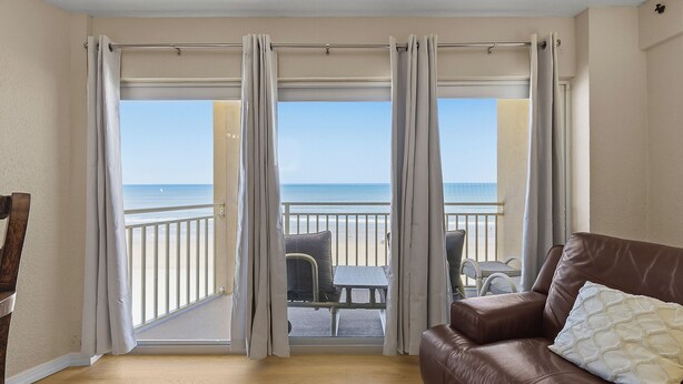 A balcony with a view of the sea, a brown leather sofa, and a small table with chairs. - ☀️Oceanfront | Direct Beach Access | Two Pools | Daytona Inn Beach Resort 409☀️ (Daytona Beach)