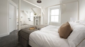 A bedroom with a bed, a window, a wardrobe, and a desk. - Harbour Watch Cottage – Sea View Cottage in Newlyn, Cornwall (Newlyn)