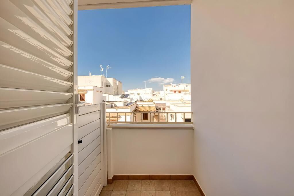 A balcony with a view of neighboring buildings.