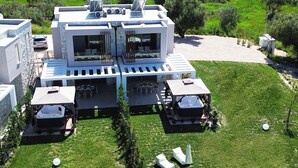 Una casa moderna con un patio, mobiliario exterior y vistas del paisaje circundante.