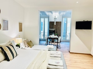 Une chambre d’hôtel avec un lit, un bureau et une télévision. Elle dispose d’un balcon avec vue.