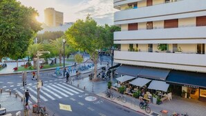 Een hotel met meerdere verdiepingen, buiten zitplaatsen en een fietsenstalling.