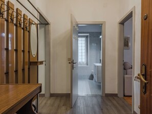 A hallway leading to a bathroom with a toilet, sink, and shower. - Catherine by Interhome (Pellizzano)