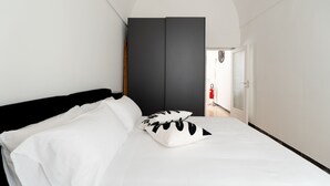A bedroom with a bed, a wardrobe, and a door leading to a hallway. - Casa Argento by Monholiday (Monopoli)