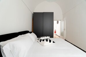 Ein Schlafzimmer mit einem Bett, einem Kleiderschrank und einer Tür zu einem Flur.