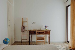 A room with a wooden desk, a chair, a ladder, a globe, and a window with curtains. - Casa Elios by Monholiday (Monopoli)