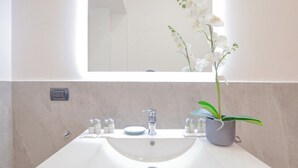 A bathroom with a white sink, a mirror, a potted orchid, and a small window. - Flatsharing - Scarlatti - 2 camere (Milan)