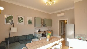 A modern kitchen with a dining area, a sofa, and a refrigerator. - Flatsharing - Scarlatti - 3 camere (Milan)