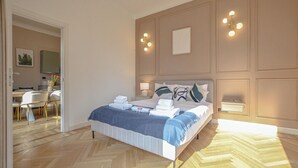 Ein Schlafzimmer mit Bett, Nachttischen, einem Schreibtisch und Stühlen.