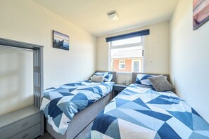A bedroom with two beds, a window, a picture on the wall, and a bedside table. - 3 Bedrooms Sleeps 6 Spacious Chalet Log Burner (Bridlington)