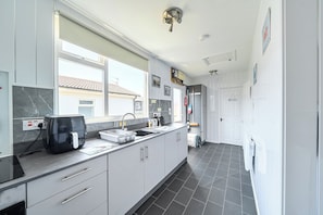 A modern kitchen with a large window, a built-in oven, and a sink. - 3 Bedrooms Sleeps 6 Spacious Chalet Log Burner (Bridlington)