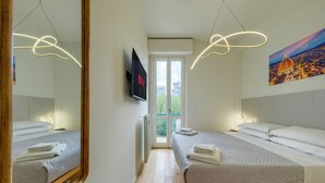 Ett modernt hotellrum med två sängar, en stor spegel, en platt-TV och en tavla som föreställer en stadsbild.