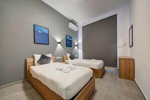 A modern hotel room with two beds, a large window, and a view of the sky. - Kuya Suite No.1 / Central / Terrace (Swieqi)